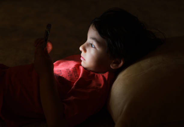 istock Cute little boy playing with a smartphone at night 1498795475