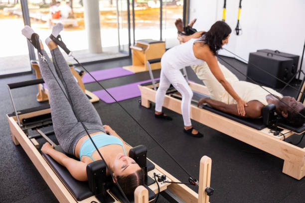 istock Active young Woman doing pilates exercises lying on pilates workout machines 1498797215