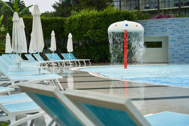 una serie de tumbonas vacías cerca de la piscina bajo sombrillas cerradas - tourist resort apartment swimming pool caribbean fotografías e imágenes de stock