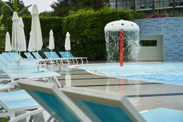 un certain nombre de chaises longues vides près de la piscine sous des parasols fermés - tourist resort apartment swimming pool caribbean photos et images de collection