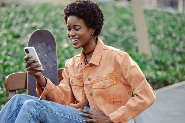 istock African American woman using smart phone on bench in the park 1498804113