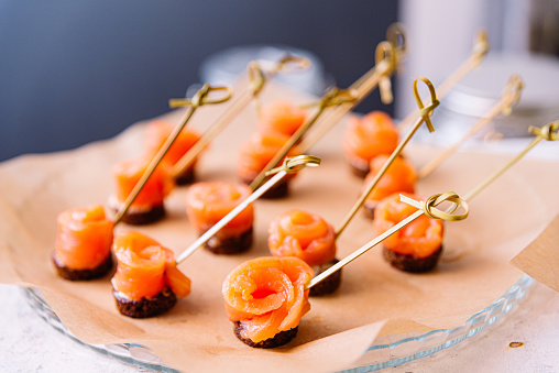 Canape with smoked salmon on wooden skewers, selective focus.