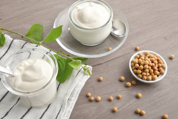 yogourts de soja et bol avec grains sur banc en bois - yogurt jar cream milk photos et images de collection