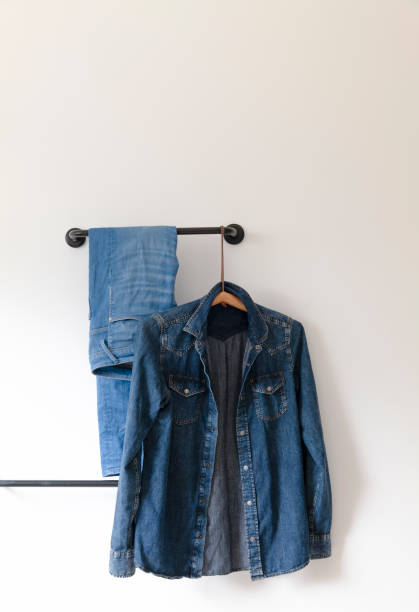 istock Blue shirt and jeans hanging against white wall 1498810782
