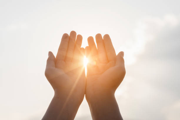 istock Human hands praying to god on mountain sunset background 1498811687