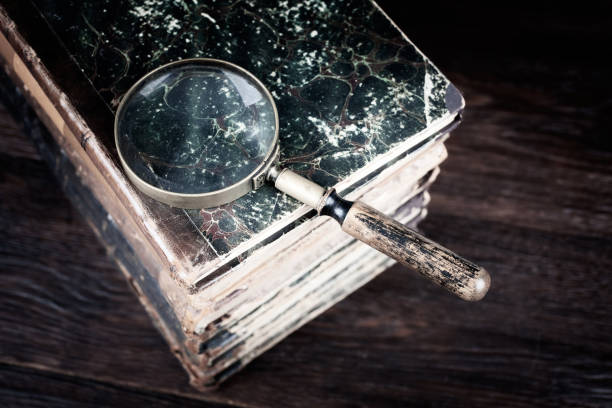 istock Old vintage magnifying glass with books on table 1498812970
