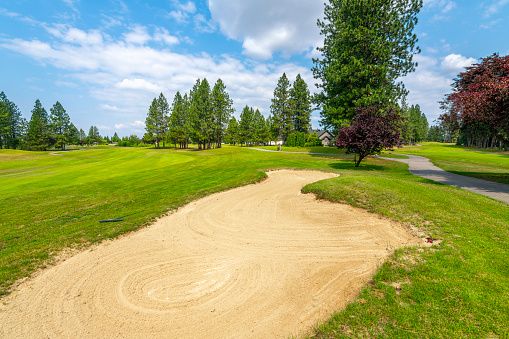 View of a sand trap, fairway and green at the Highlands Golf Course, an exclusive golf community of high end homes in the rural city of Post Falls, Idaho, in the Coeur d'Alene area of North Idaho.