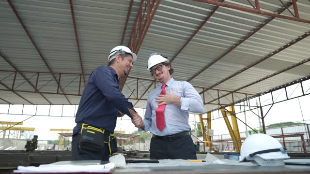 Engineers and architects meeting and planning together at construction site, The construction team shakes hands after reaching a consensus.