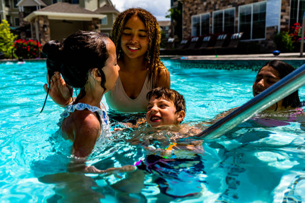 istock Four multiethnic siblings joyfully splash and play in a pool on a scorching summer day. Their diverse ages, hairstyles, and backgrounds create a beautiful tapestry of unity and happiness. 1498816453