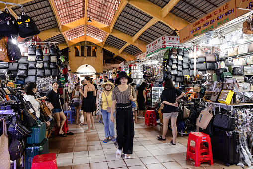 Locals and tourists walking along Ben Thanh Market in Ho Chi Minh City, Vietnam