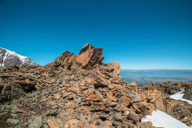 Scenic mountain landscape with old rocks and stones among snow in sunlight. Awesome alpine scenery with stone outliers on high mountain under blue sky in sunny day. Sharp rocks at very high altitude. paisaje escénico de montaña con rocas y piedras antiguas entre la nieve a la luz del sol. impresionante paisaje alpino con valores atípicos de piedra en alta montaña bajo el cielo azul en un día soleado. rocas afiladas a muy gran altitud.