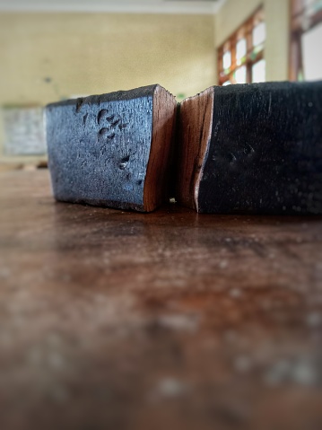 A small piece of wood was damaged and split, The wood was placed on the wooden table, macro photography