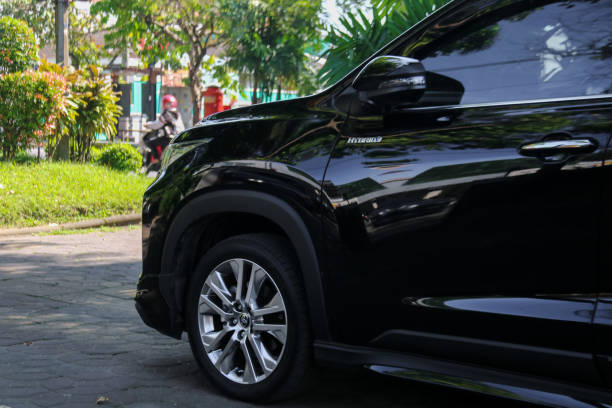 Side view of a Toyota kijang innova zenix Surakarta, Indonesia - May 16, 2023: Side view of a Toyota kijang innova zenix hybrid on a parking area. Tyre and alloy wheel. kijang stock pictures, royalty-free photos & images