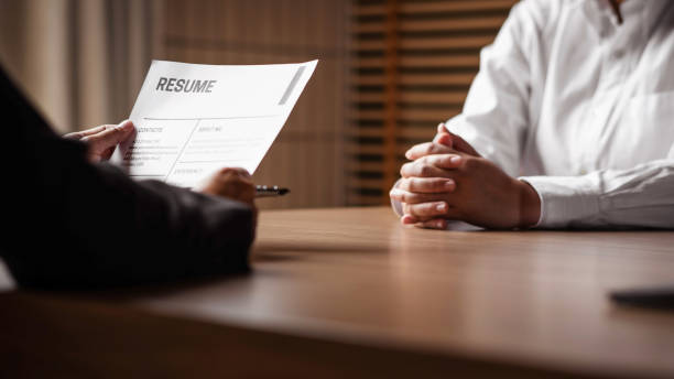 Image of employer or recruiter holding reading a resume during about colloquy his profile of candidate. stock photo