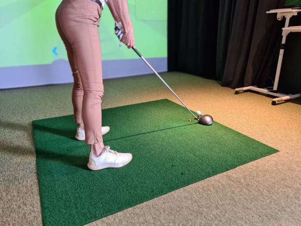 istock Professional female golfer playing golf indoors on golf simulator closeup 1498838364