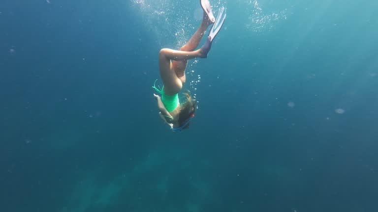 Freediver woman swimming over coral reef