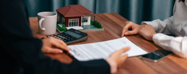 istock Reviewing house loan contract with agent using calculator. Enthusiastic 1498844211