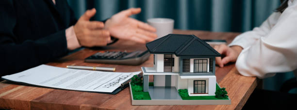 Reviewing house loan contract with agent using calculator. Enthusiastic