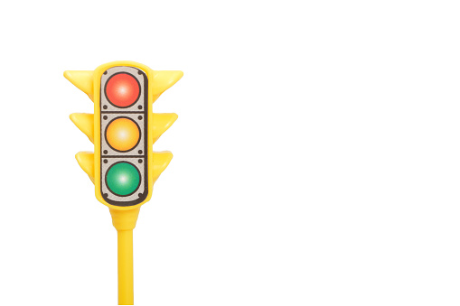 Yellow toy traffic light isolated on a white background.