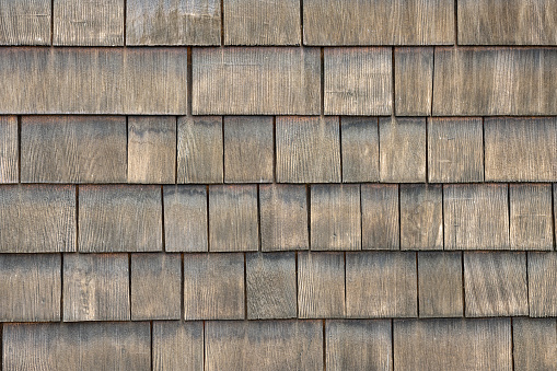 Dormer in roof of house with cedar shingles.