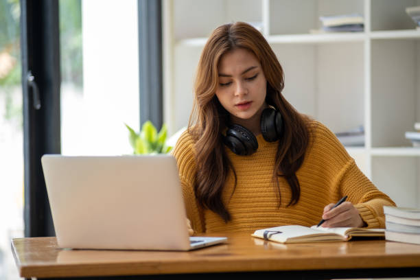 istock Distance Education. E-learning, Study online, Smiling beautiful woman sitting at desk and wearing headphone head set study online class zoom google meet discord, Happy engaged girl attending for learn 1498848397