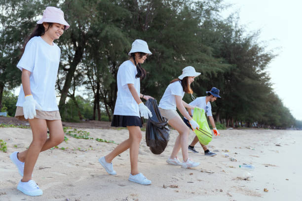 istock Volunteer picking up garbage activity on the beach after tourist resting in holidays weekend travel people lifestyle. 1498852898