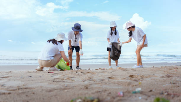 istock Volunteer picking up garbage activity on the beach after tourist resting in holidays weekend travel people lifestyle. 1498853010