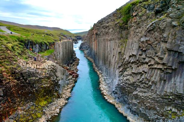istock a river in the middle of a canyon by some tall rocks 1498853049