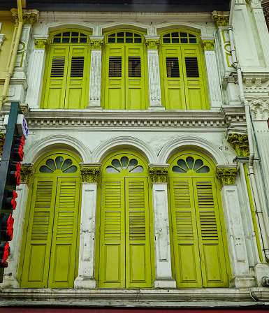 Yellow wooden windows of an ancient building in Chinatown, Singapore.