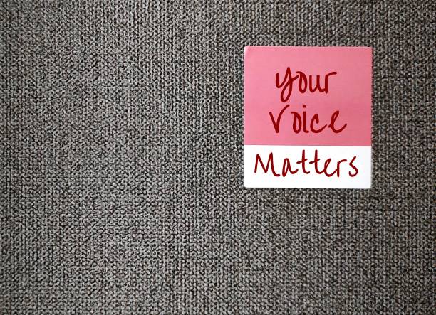 당신의 목소리가 중요하다는 텍스트가 쓰여진 벽지에 분홍색 스티커, 하나의 내부 세계를 공공 장소로 표현하는 개념, 모든 목소리를 들을 가치가 있습니다. - 어린이의 권리 뉴스 사진 이미지