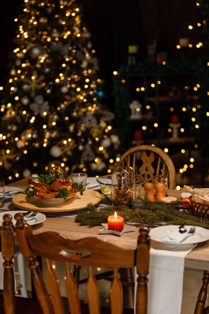 istock Christmas lights glistening in the background behind a rustic dining table set for a Christmas dinner party 1498856092