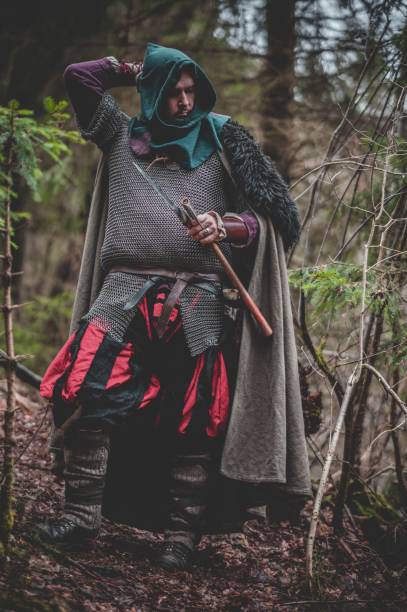 istock Man dressed in authentic medieval armor standing in the middle of forest 1498863674