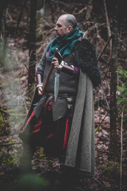 istock Man dressed in authentic medieval armor standing in the middle of forest 1498863677