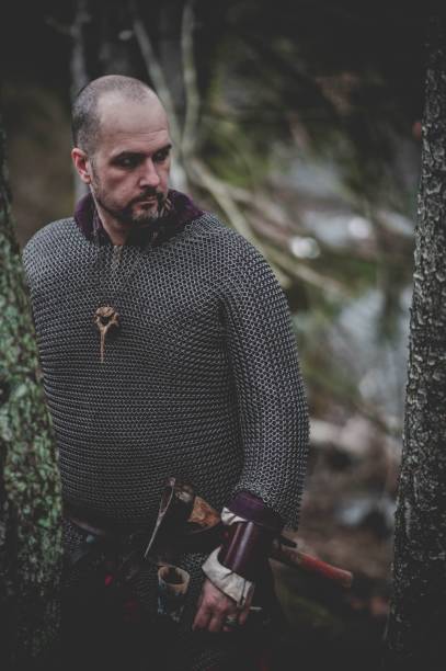 istock Man dressed in authentic medieval armor standing in the middle of forest 1498863682