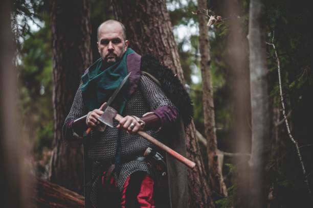istock Man dressed in authentic medieval armor standing in the middle of forest 1498863692