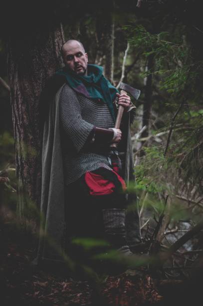 istock Man dressed in authentic medieval armor standing in the middle of forest 1498863703