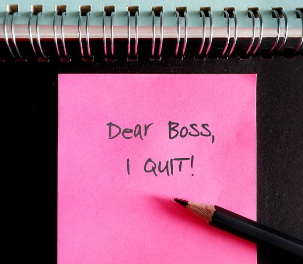 istock Bright pink note on black notebook page with text handwriiten DEAR BOSS I QUIT , concept of decision to resign or quit from job 1498863744
