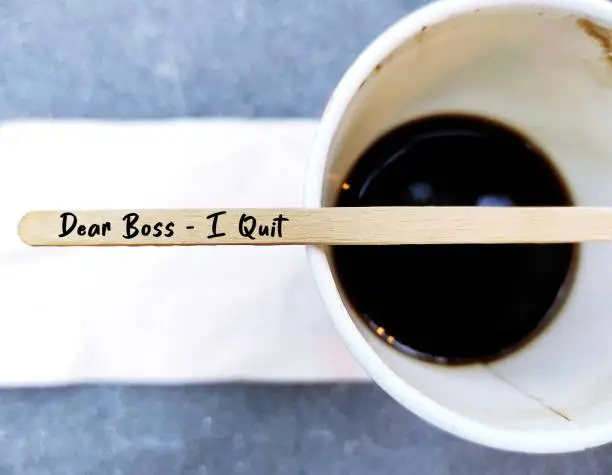Coffee stirer with text handwritten DEAR BOSS I QUIT on coffee cup, decision making to quit job or resign from corporate full time work, employee voluntarily leaving job to find work life balance