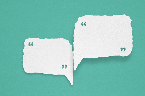 For conceptual image about communication and social media, customer feedback, couple white torn speech bubble paper with quote on grunge blue background