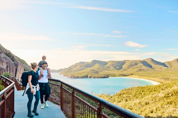Worth the walk: Bushwalking young family in Tasmania, Australia taking in the view at Freycinet NP. stock photo