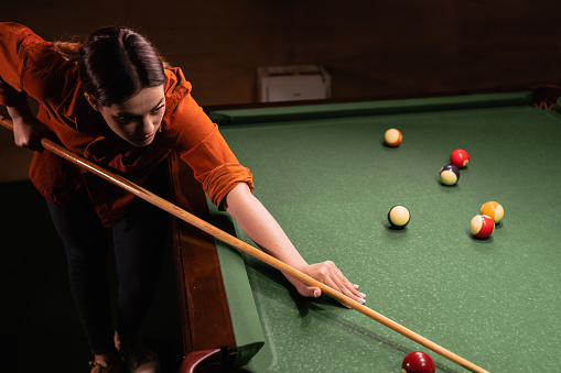 istock Close-up shot of a young woman playing billiard. Nightlife. Billiard room on the background. 1498874575