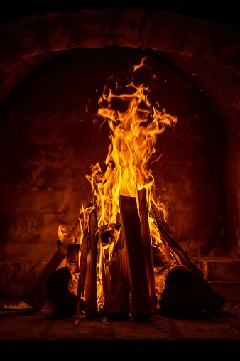 A burning wood fireplace on stone background