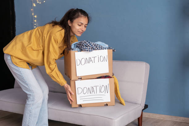 istock Donation concept. Woman taking a Donate Boxes with full of clothes 1498874731