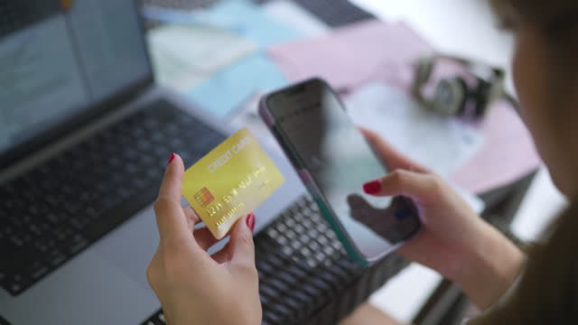 Woman inserting credit card number on mobile phone