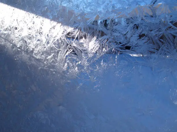 ice crystals on glass window with sunray
