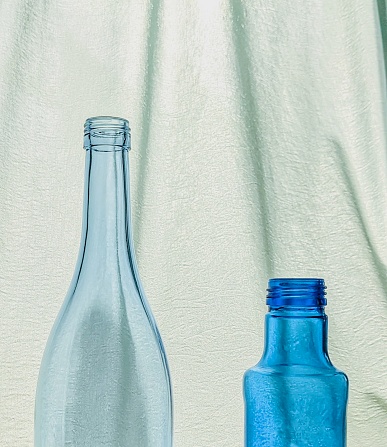 Empty blue bottles with cool looking curtains.