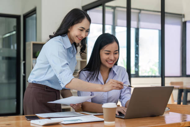 istock Business people women analyzing documents while sitting on a table in office. Woman executives at work in office discussing some paperwork 1498878341