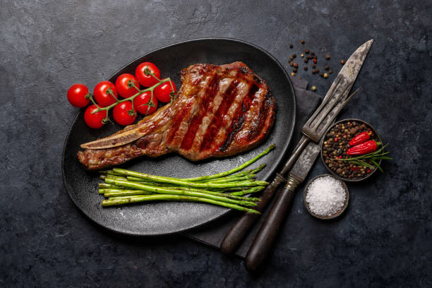 istock Medium rare grilled Tomahawk beef steak with asparagus 1498879990