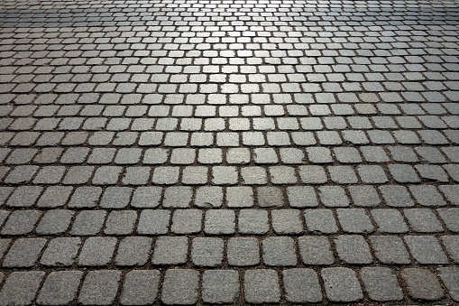 An old cobblestone street made of grey bricks closely packed together