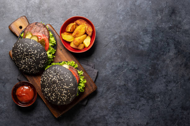 istock Homemade beef burgers with black buns 1498880956